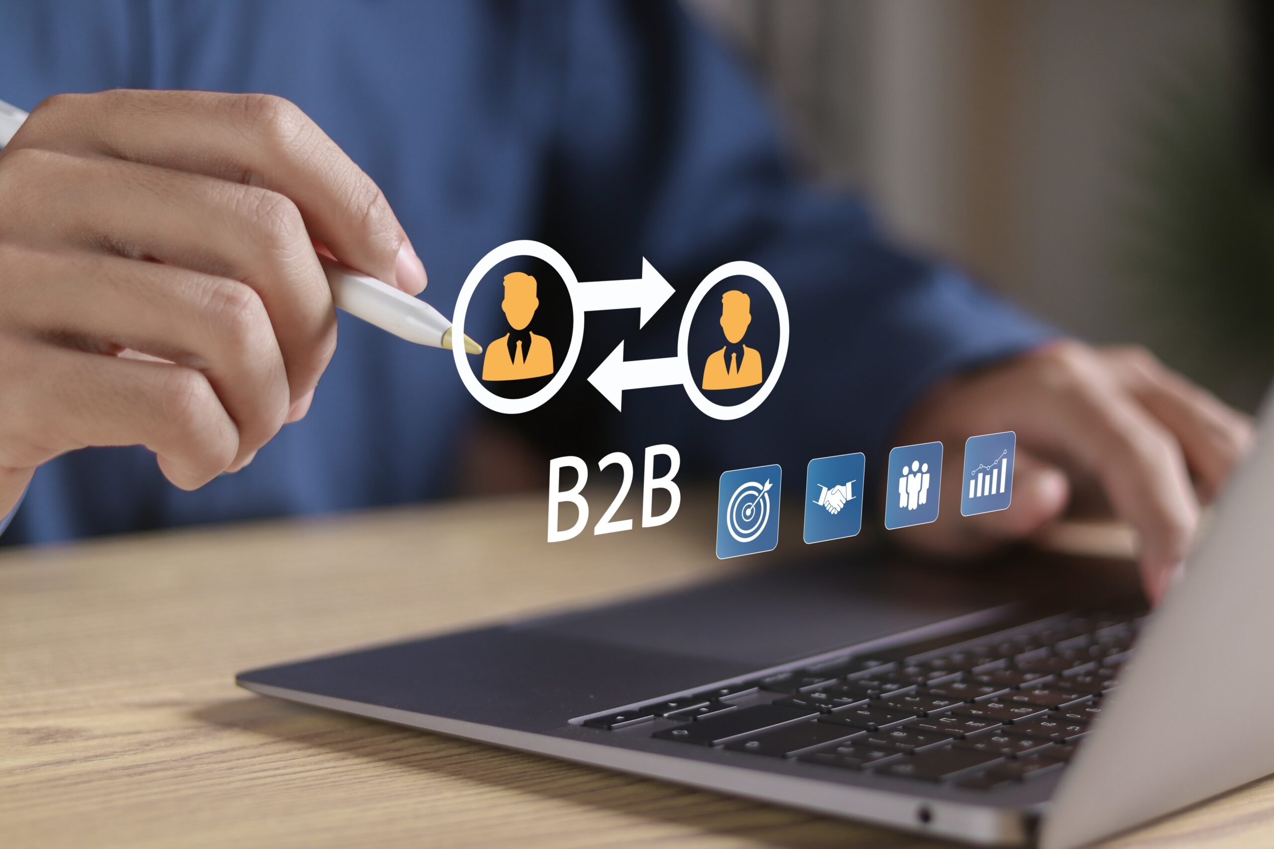Business professional using a laptop with B2B buyer and seller icons